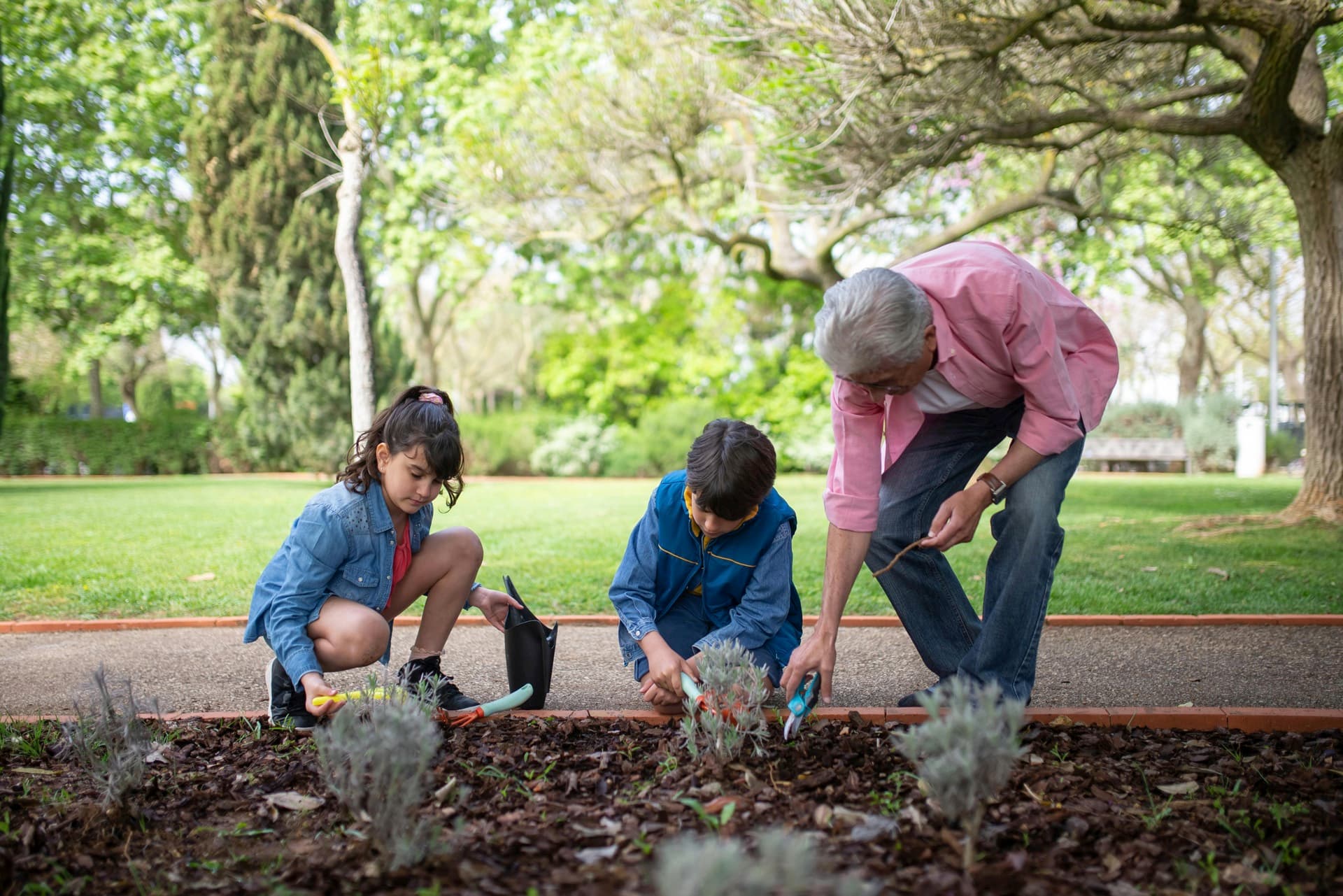 Older adult gardening with grandchildren, representing independent daily movement